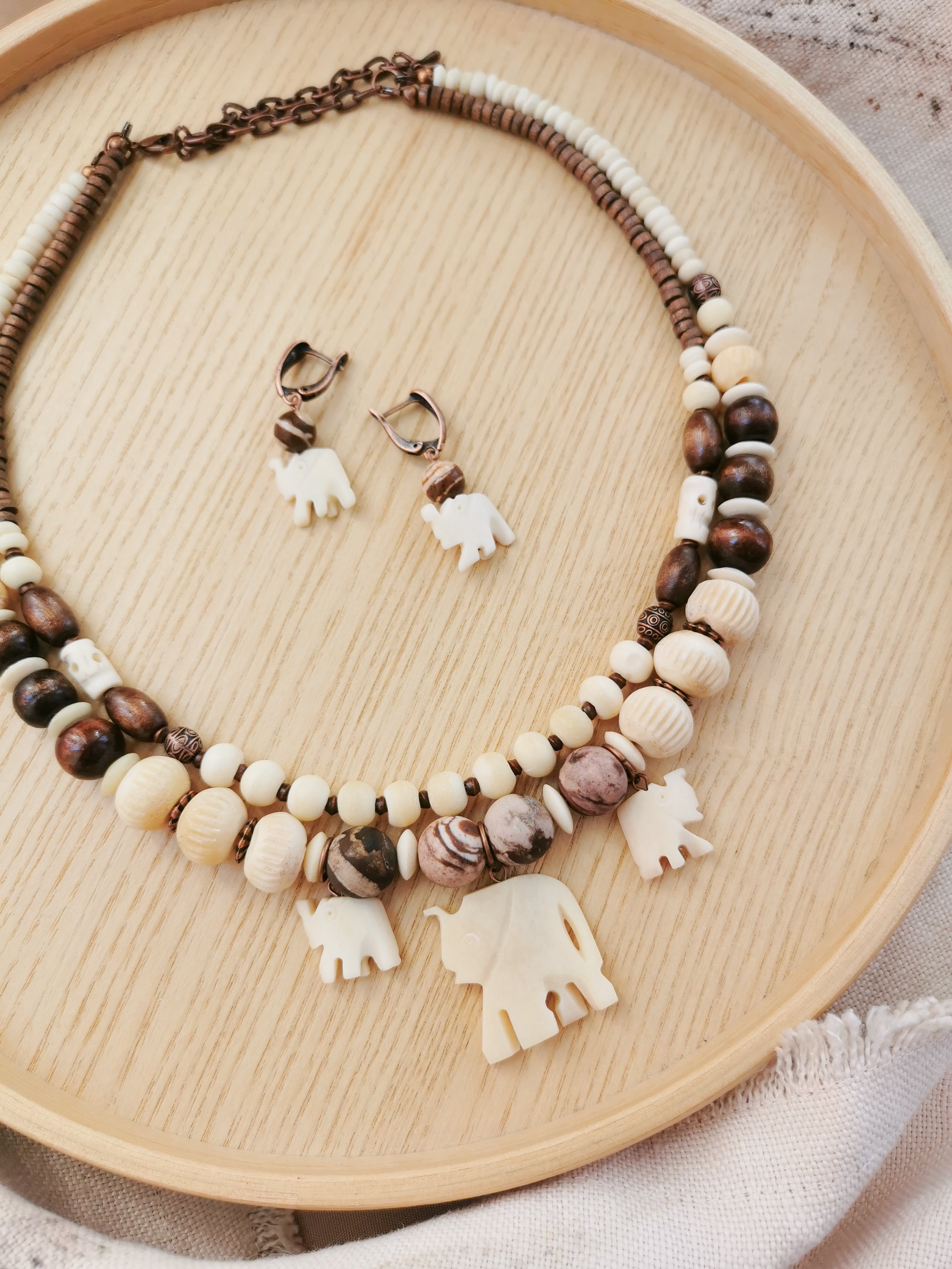 Bone bead jewelry set with elephant charms.