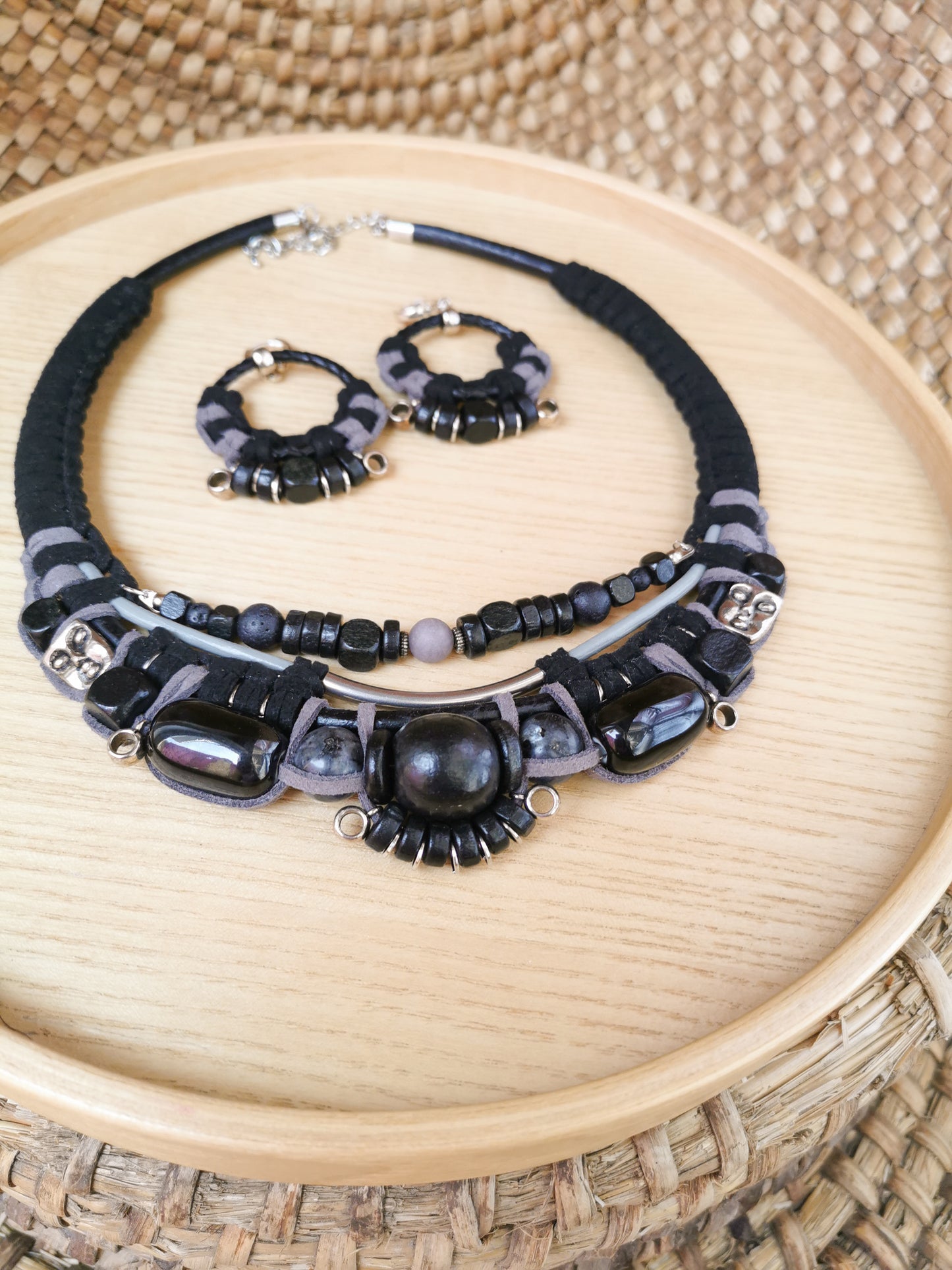 Black beaded necklace and earrings on a woven surface