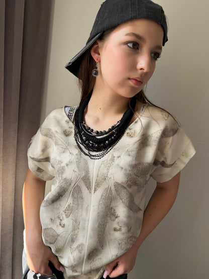 Person wearing a textured shirt and black cap indoors