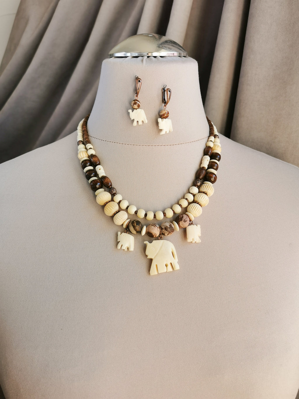 Bone bead jewelry set with elephant charms.