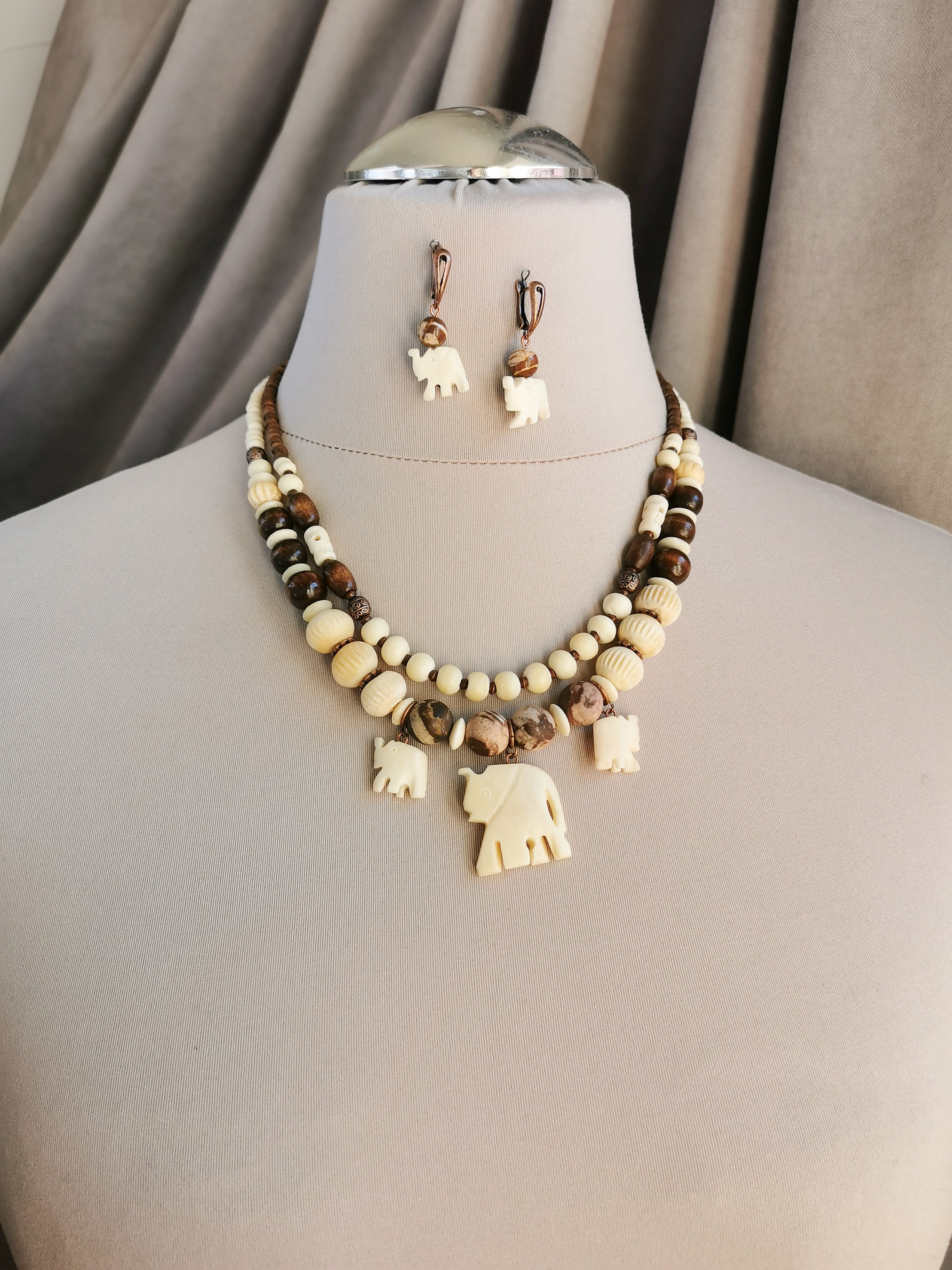 Bone bead jewelry set with elephant charms.