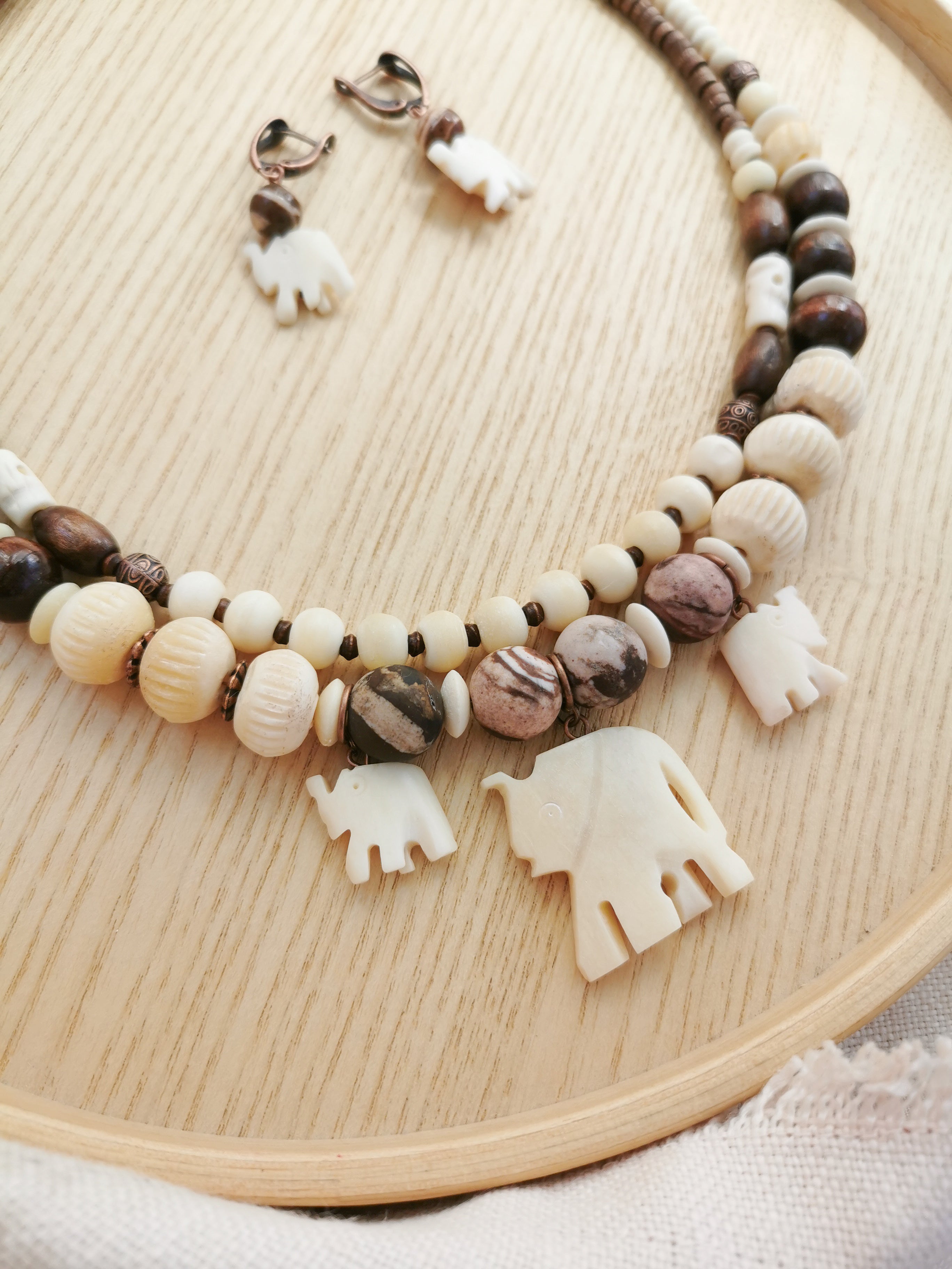 Bone bead jewelry set with elephant charms.