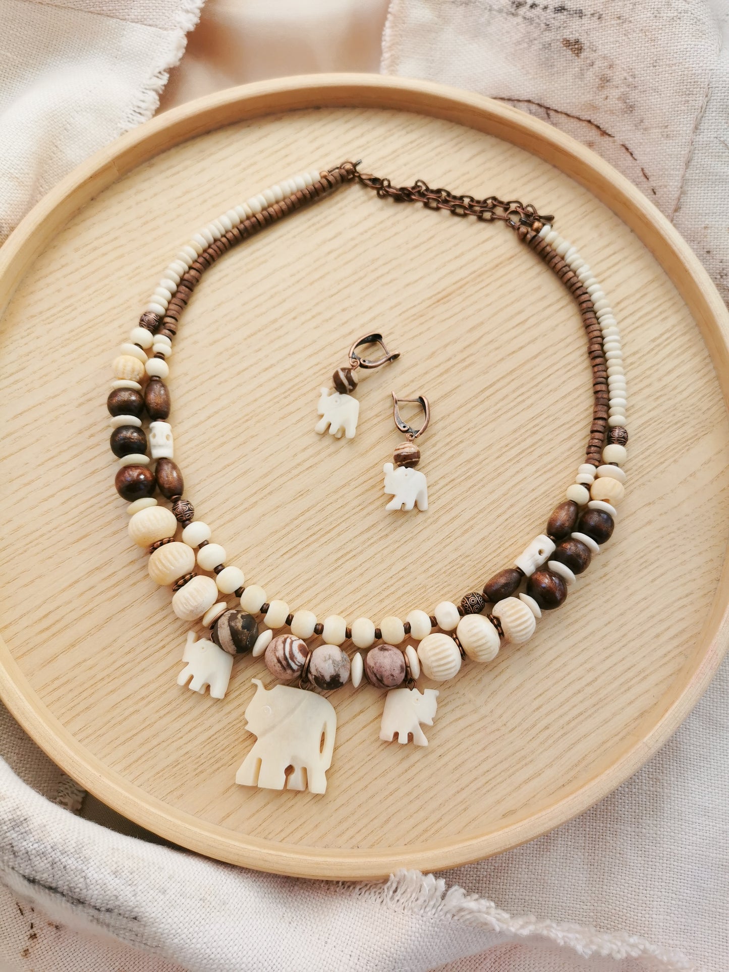 Bone bead jewelry set with elephant charms.