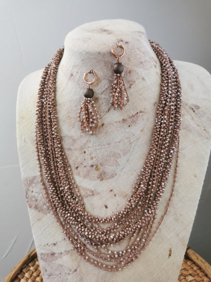 jewelry set of beige beads layering necklace and earrings on a display