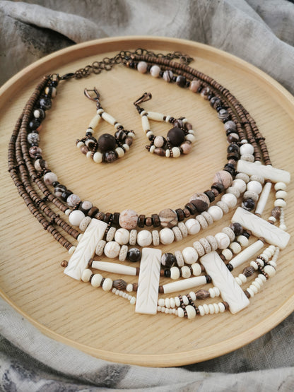 Beaded boho necklace and earrings set on a wooden plate