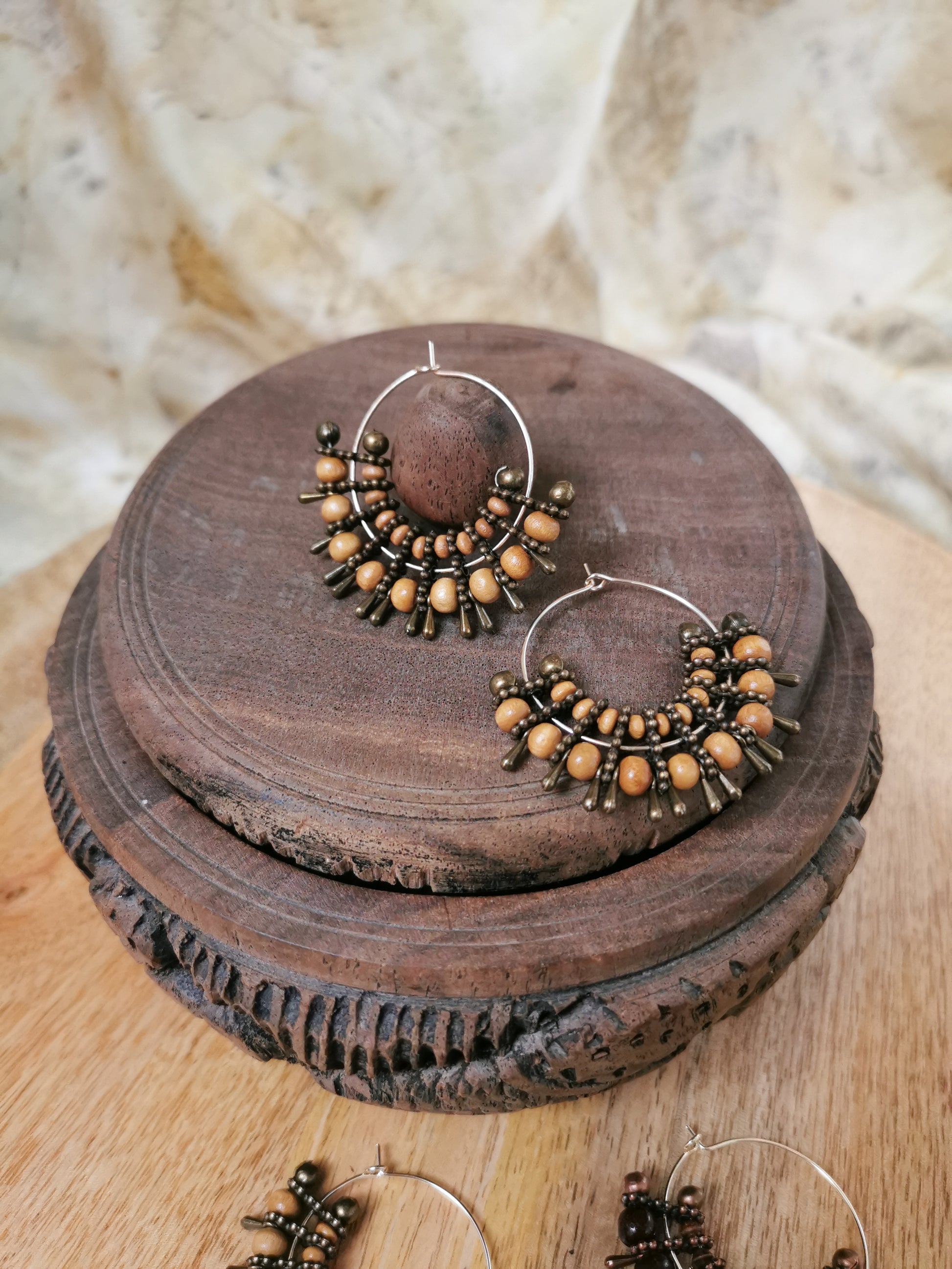 Pair of hoop earrings with beads on a wooden surface