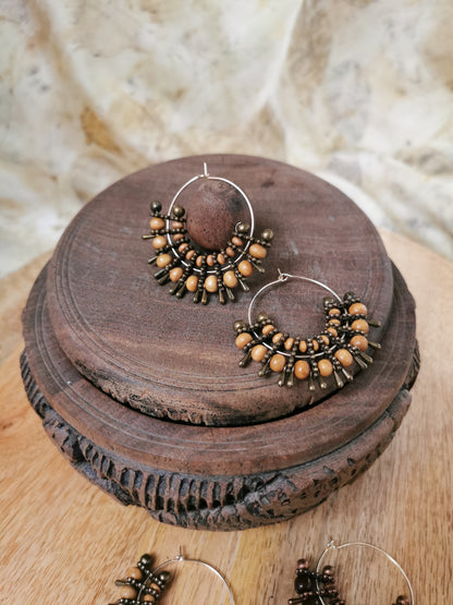 Pair of hoop earrings with beads on a wooden surface