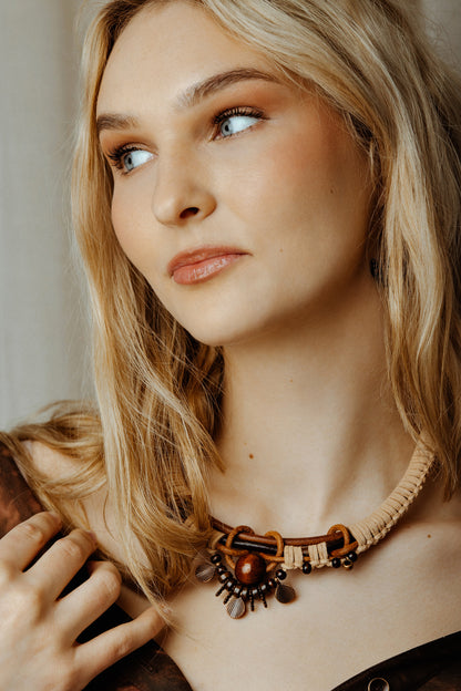 Woman wearing a boho goddess necklace with a neutral background