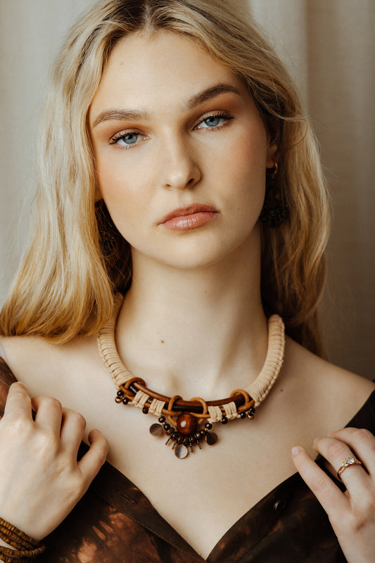 Woman wearing a decorative necklace with a neutral background