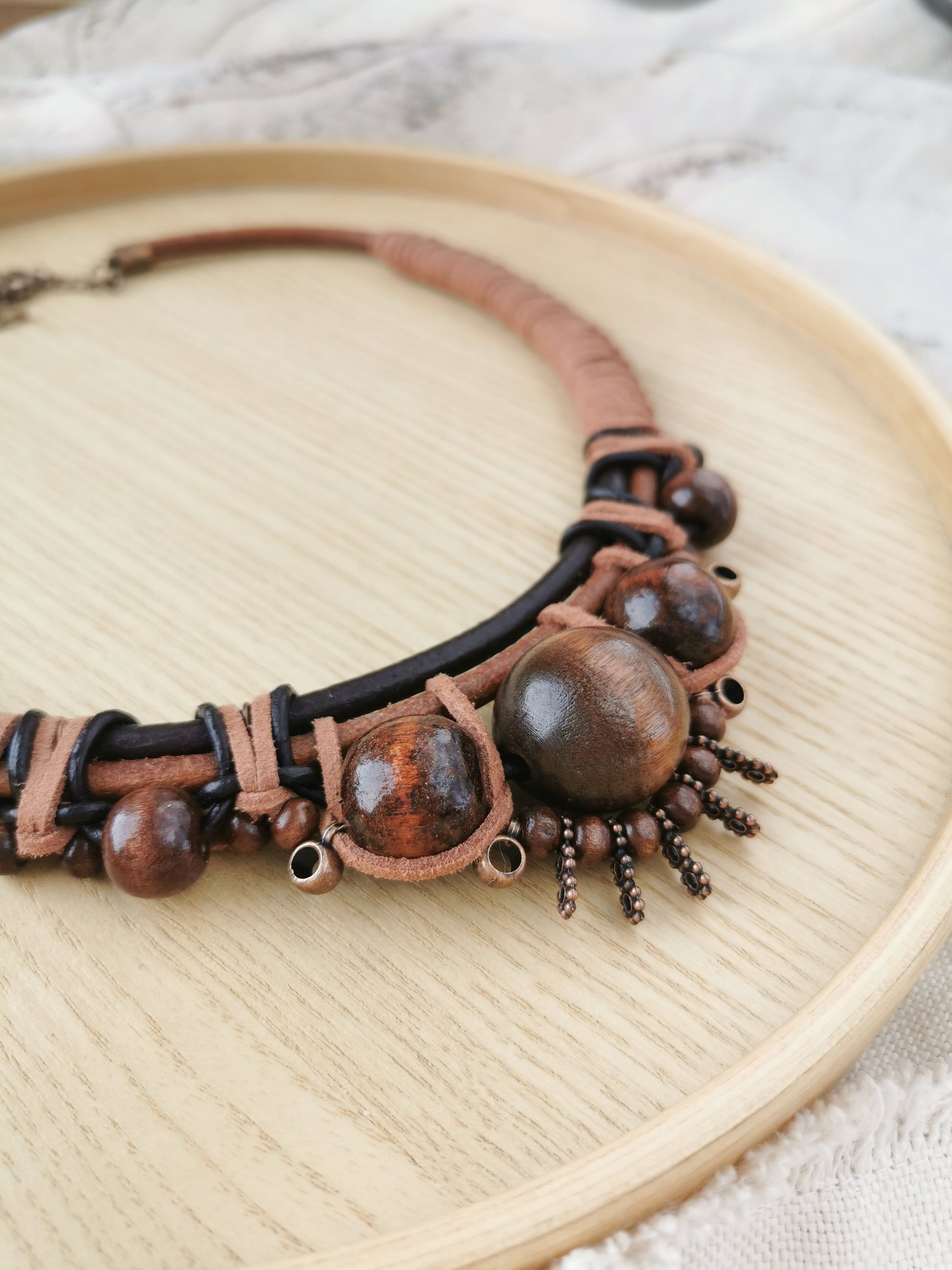 Brown boho beaded necklace on a wooden plate