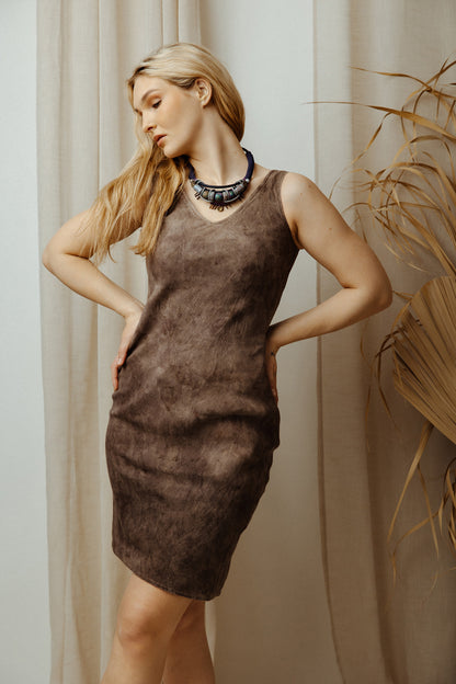Woman wearing a brown dress with a neutral background