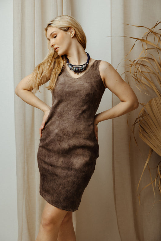 Woman wearing a brown dress with a neutral background