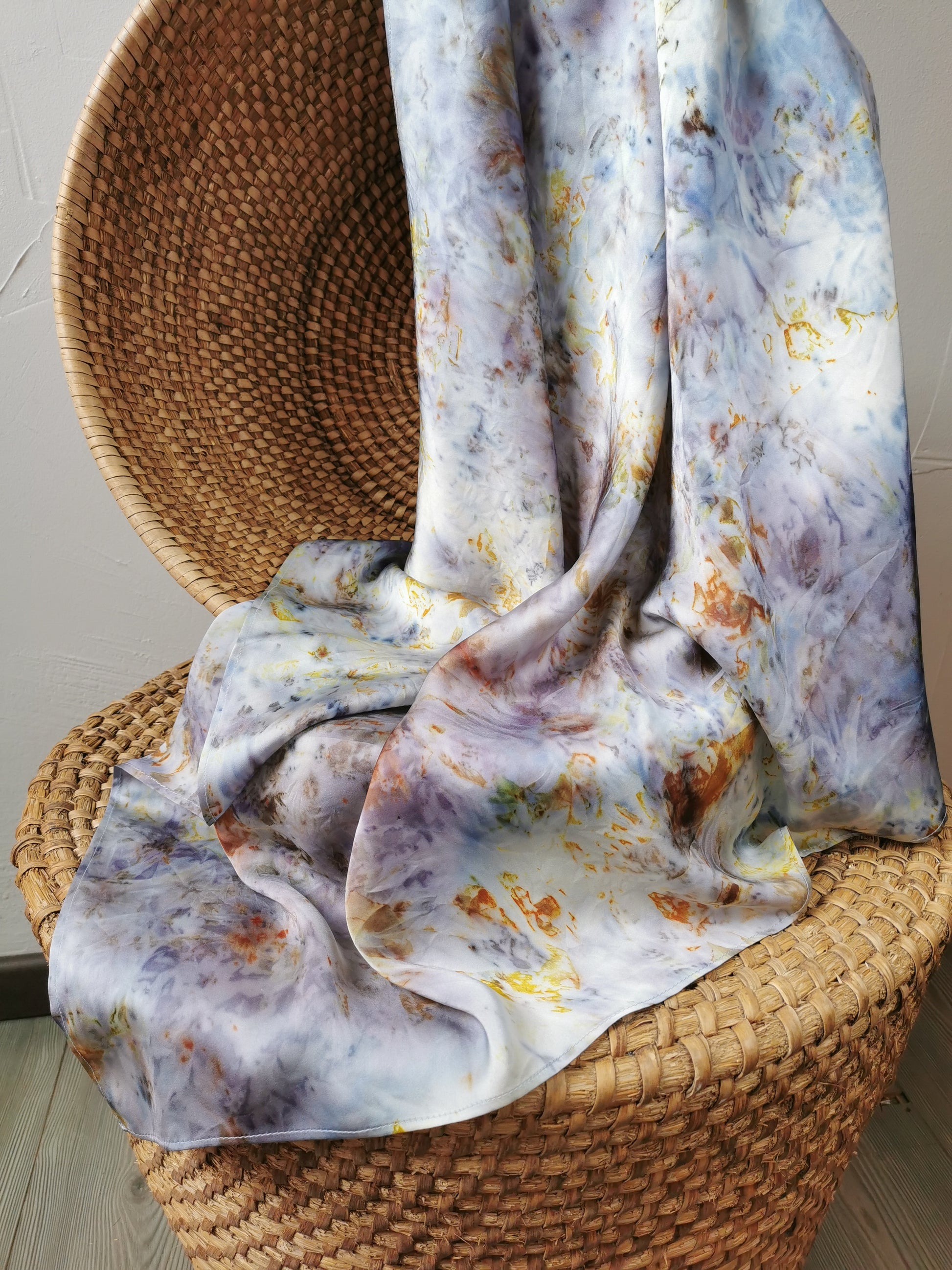 Floral-patterned silk scarf draped over a wicker chair