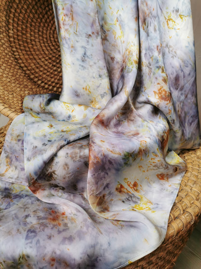 Floral-patterned silk scarf draped over a woven basket