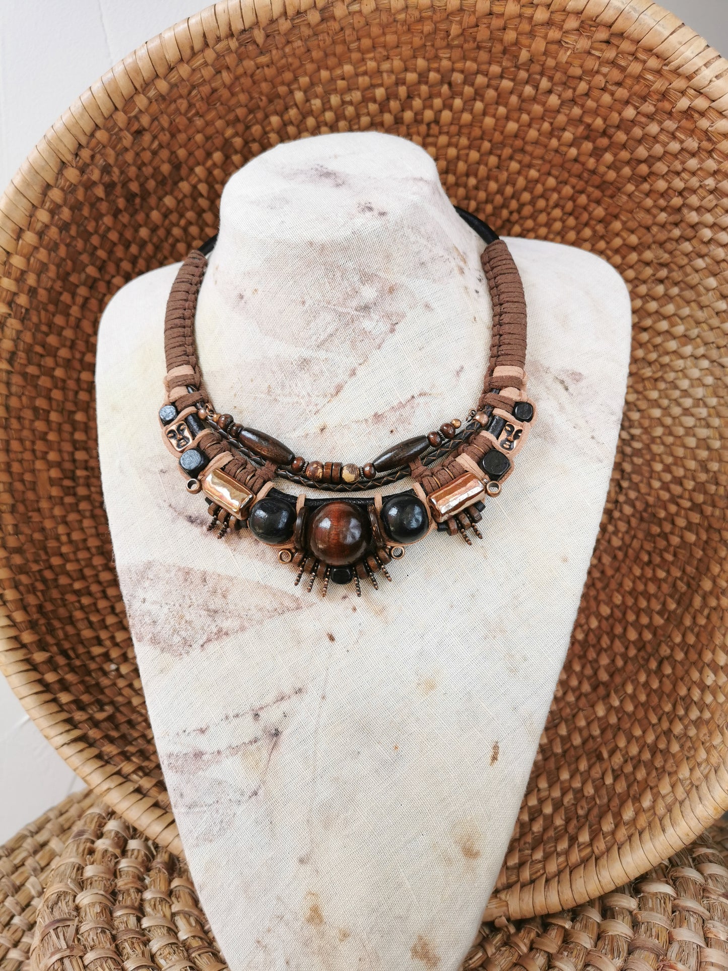 Necklace with brown and black beads on a white stone surface