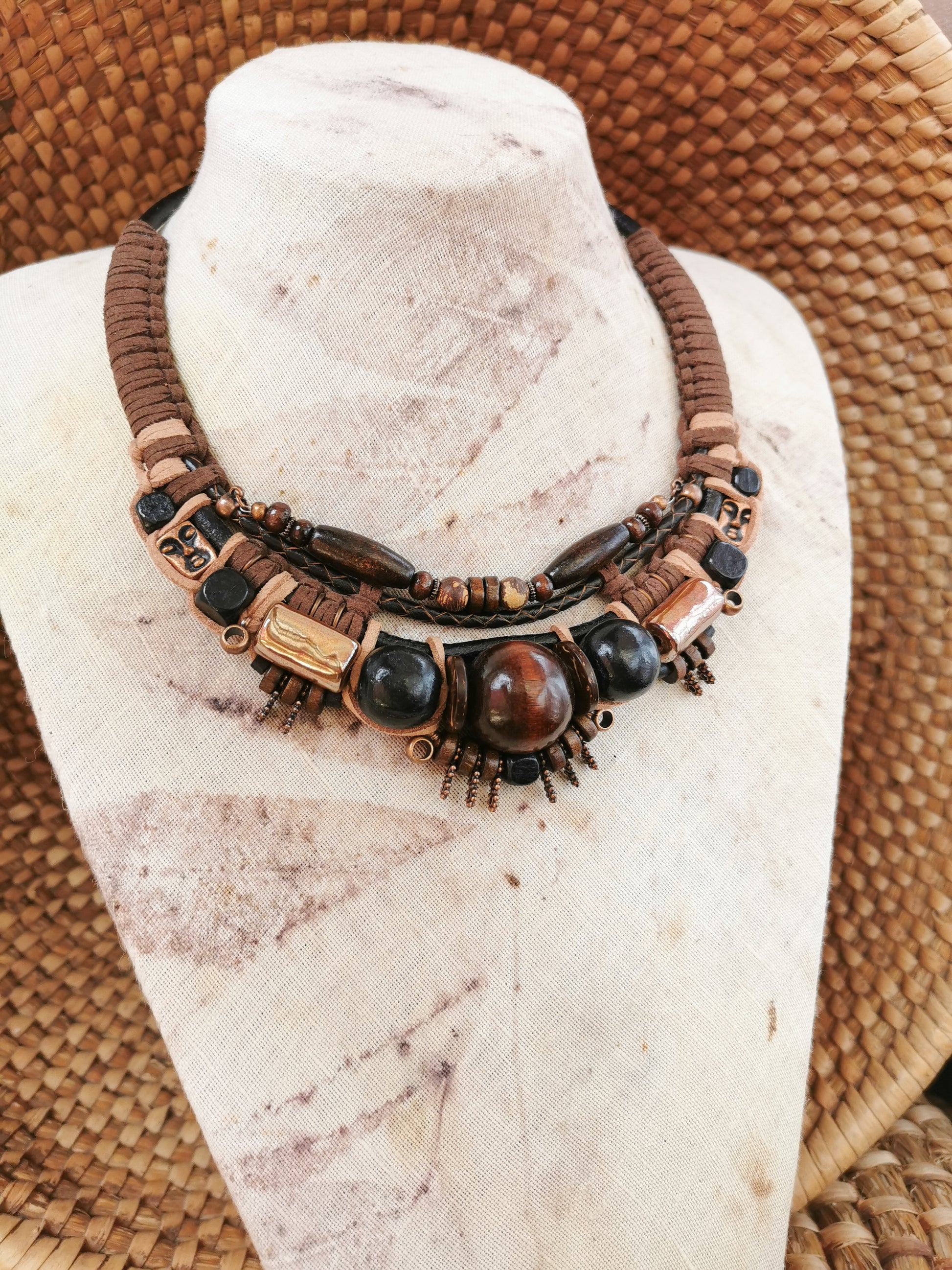 Necklace with brown and black beads on a mannequin bust.