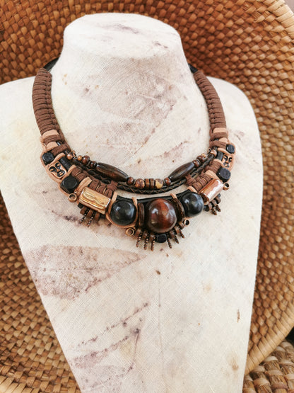 Necklace with brown and black beads on a mannequin bust.