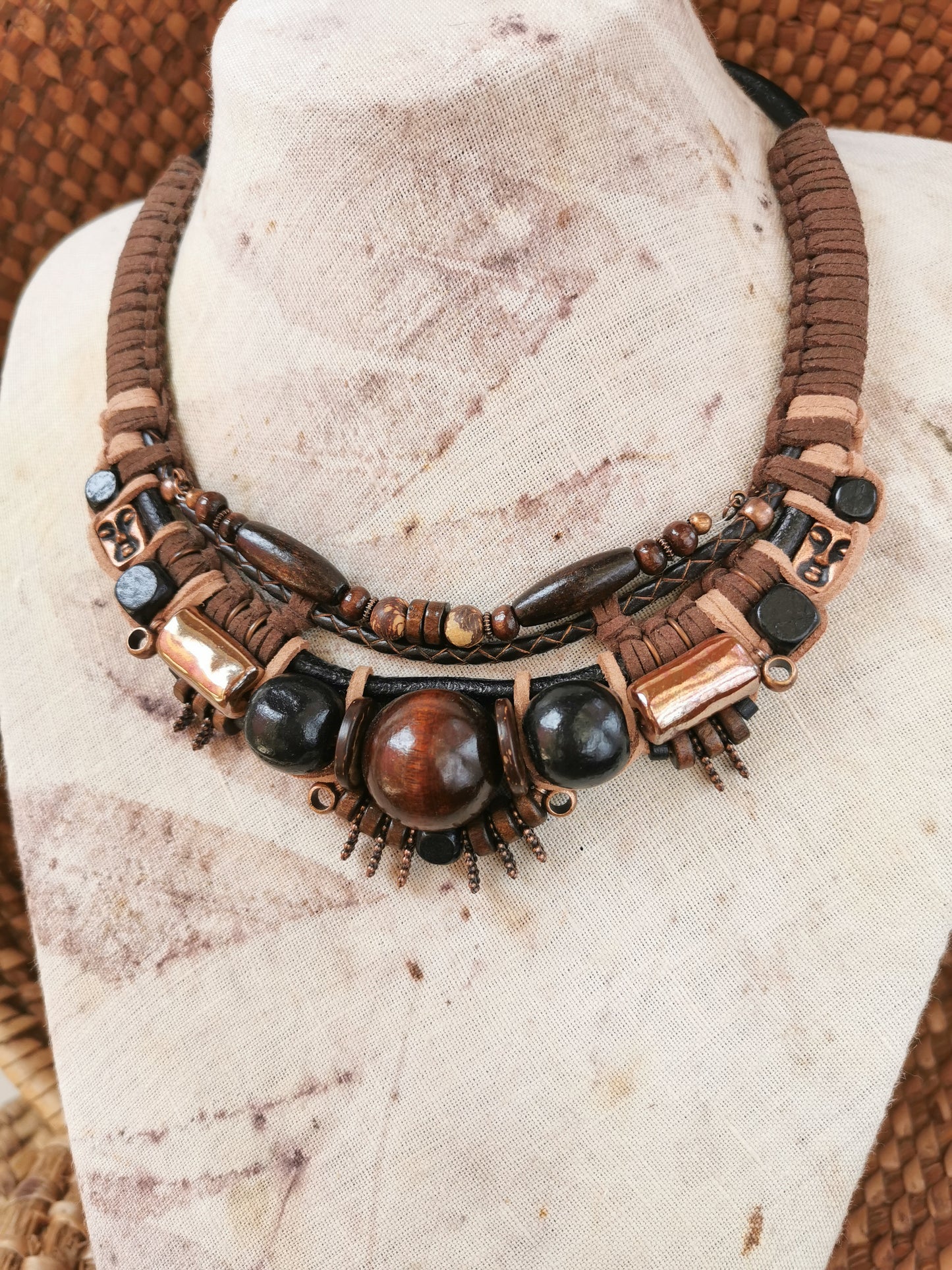 Necklace with brown and black beads on a mannequin bust.