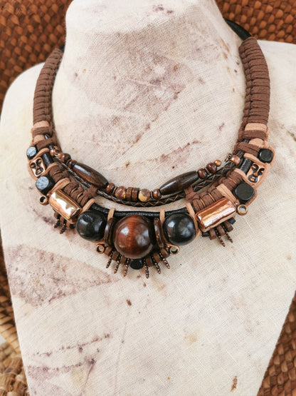 Necklace with brown and black beads on a mannequin bust.