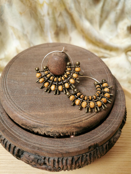 boho beaded earring on a wooden surface with a textured background