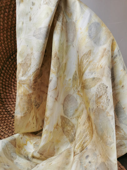 Close-up of eco-printed silk scarf with floral prints on a textured surface