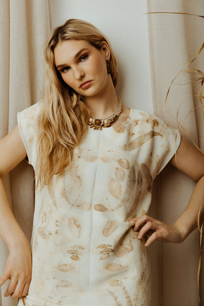 Woman wearing ivory eco print viscose dress with a neutral background