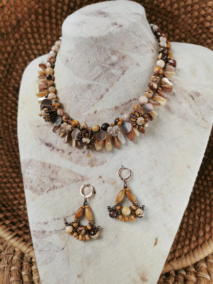 Necklace and earrings set on a marble stand with woven background