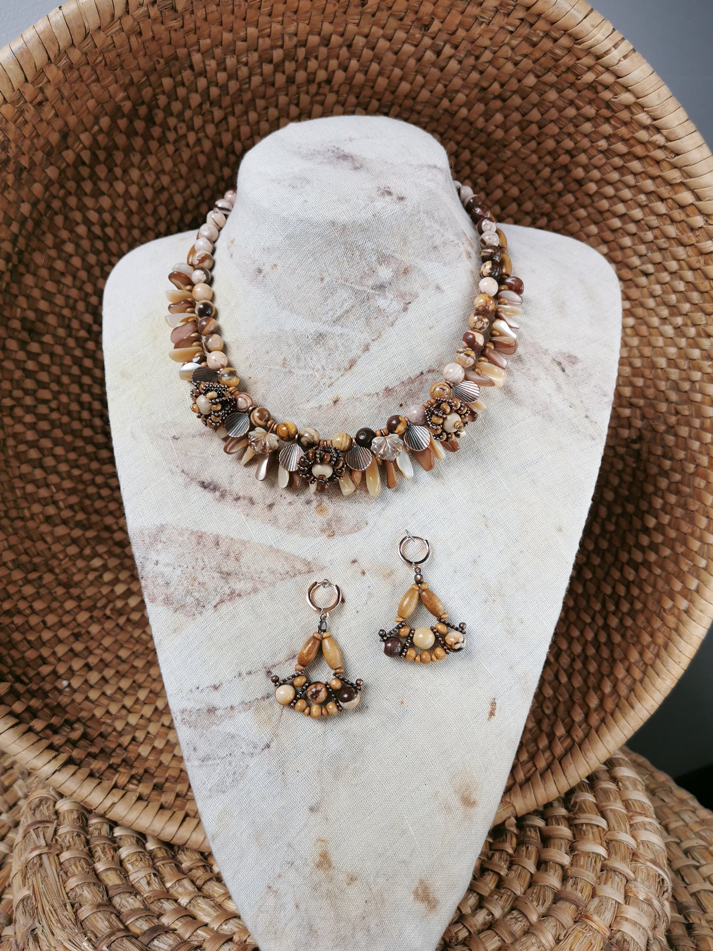 statement bead and charm necklace with earrings on a display