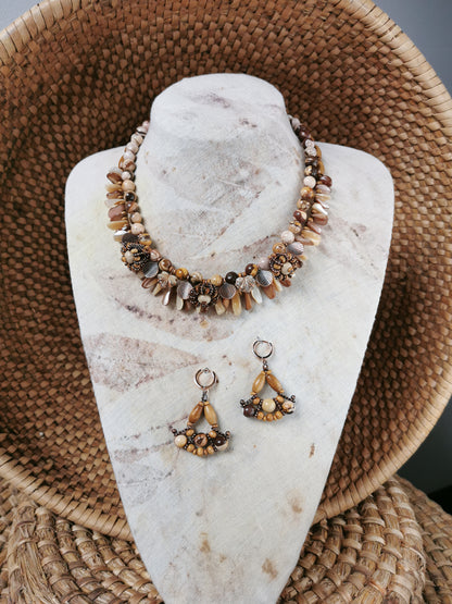 statement bead and charm necklace with earrings on a display