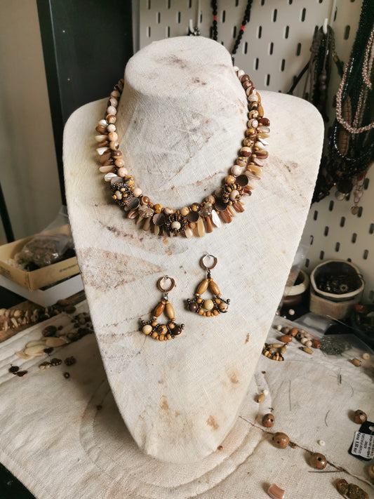 statement bead and charm necklace with earrings on a display