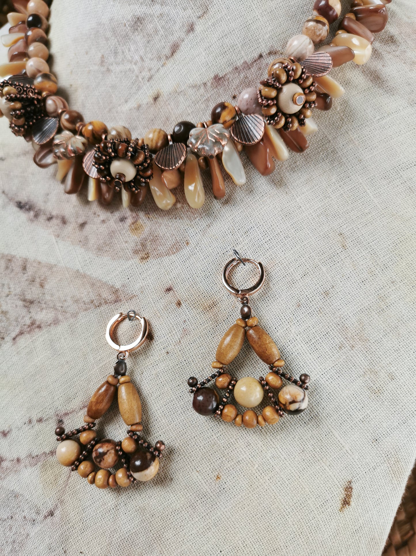 statement bead and charm necklace with earrings on a display