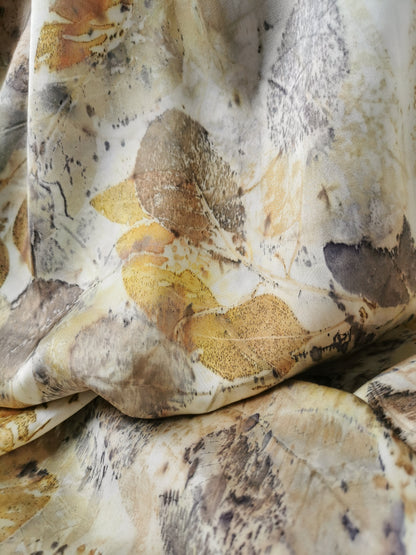 Close-up of leaf eco-printed silk scarf with brown, yellow, and beige colors.