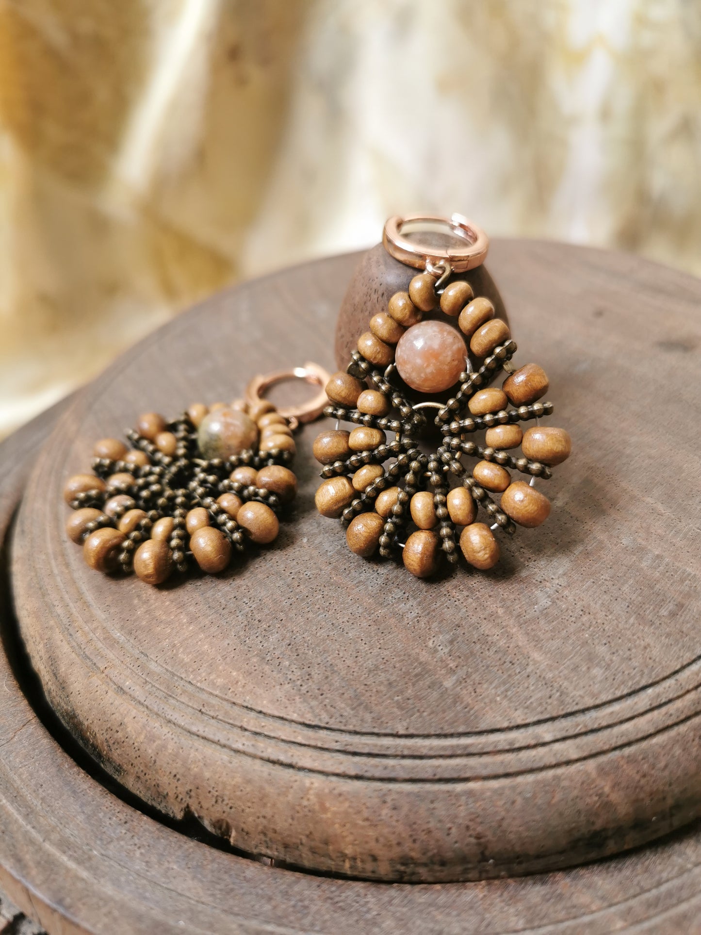Pair of boho beaded earrings on a wooden surface with a blurred background