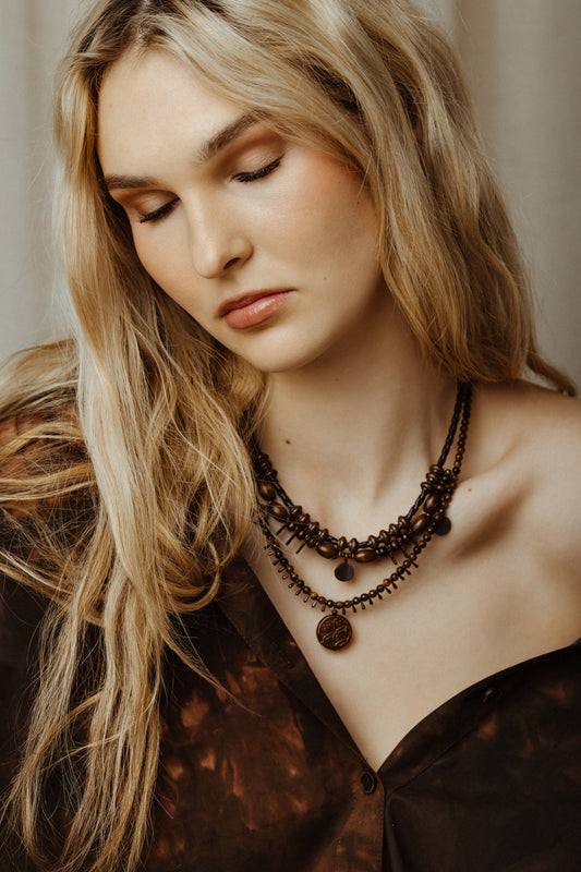 model wearing rustic bead necklace set with a neutral background