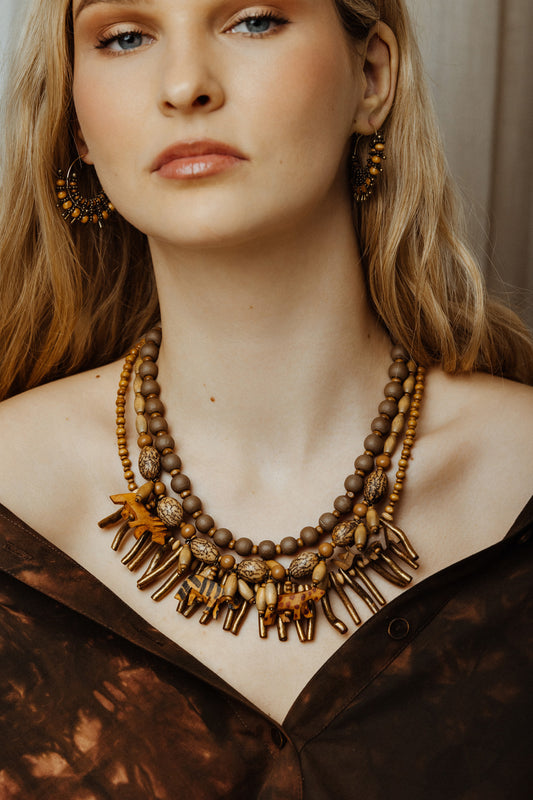 Woman wearing a detailed necklace with a neutral background