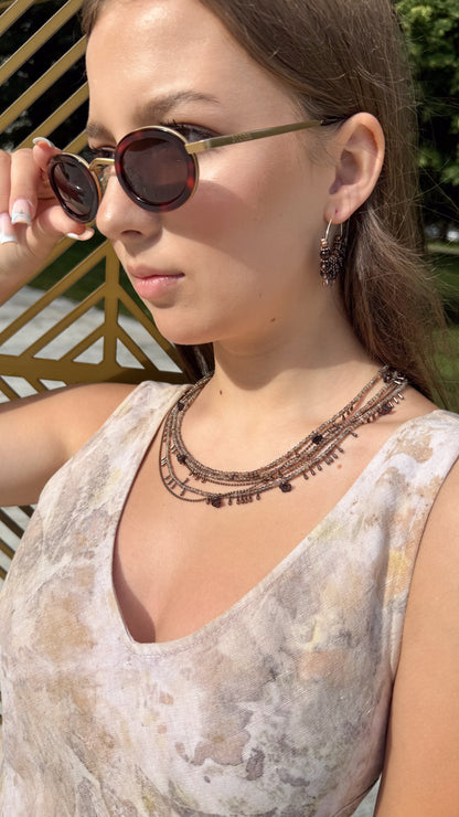 girl wearing beige linen dress and multilayer  seed bead necklace