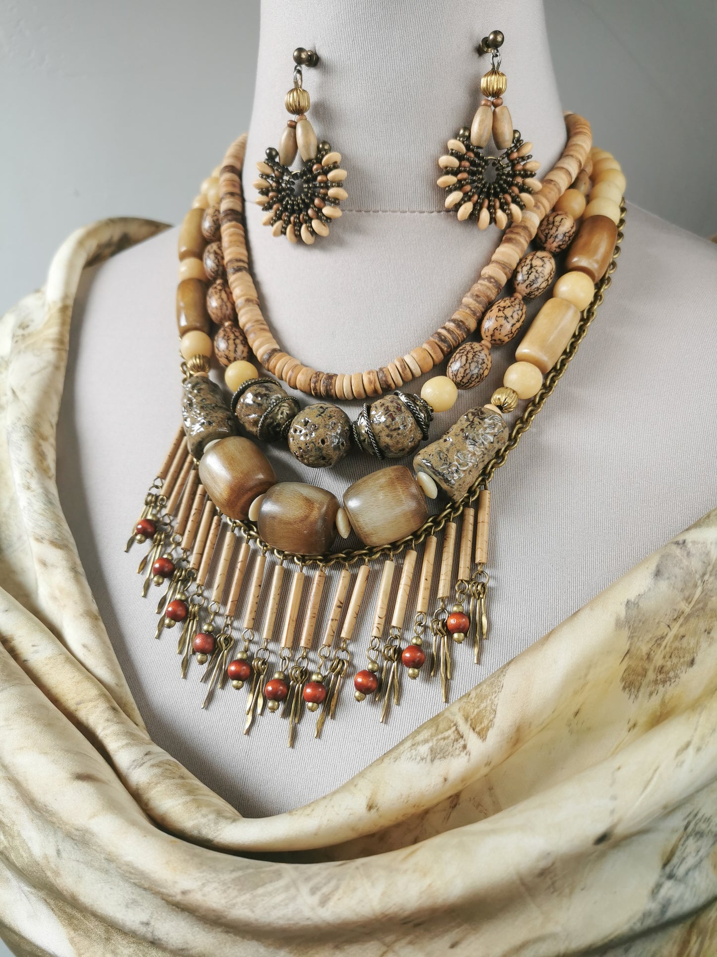 Necklace and earrings set on a mannequin with a neutral background