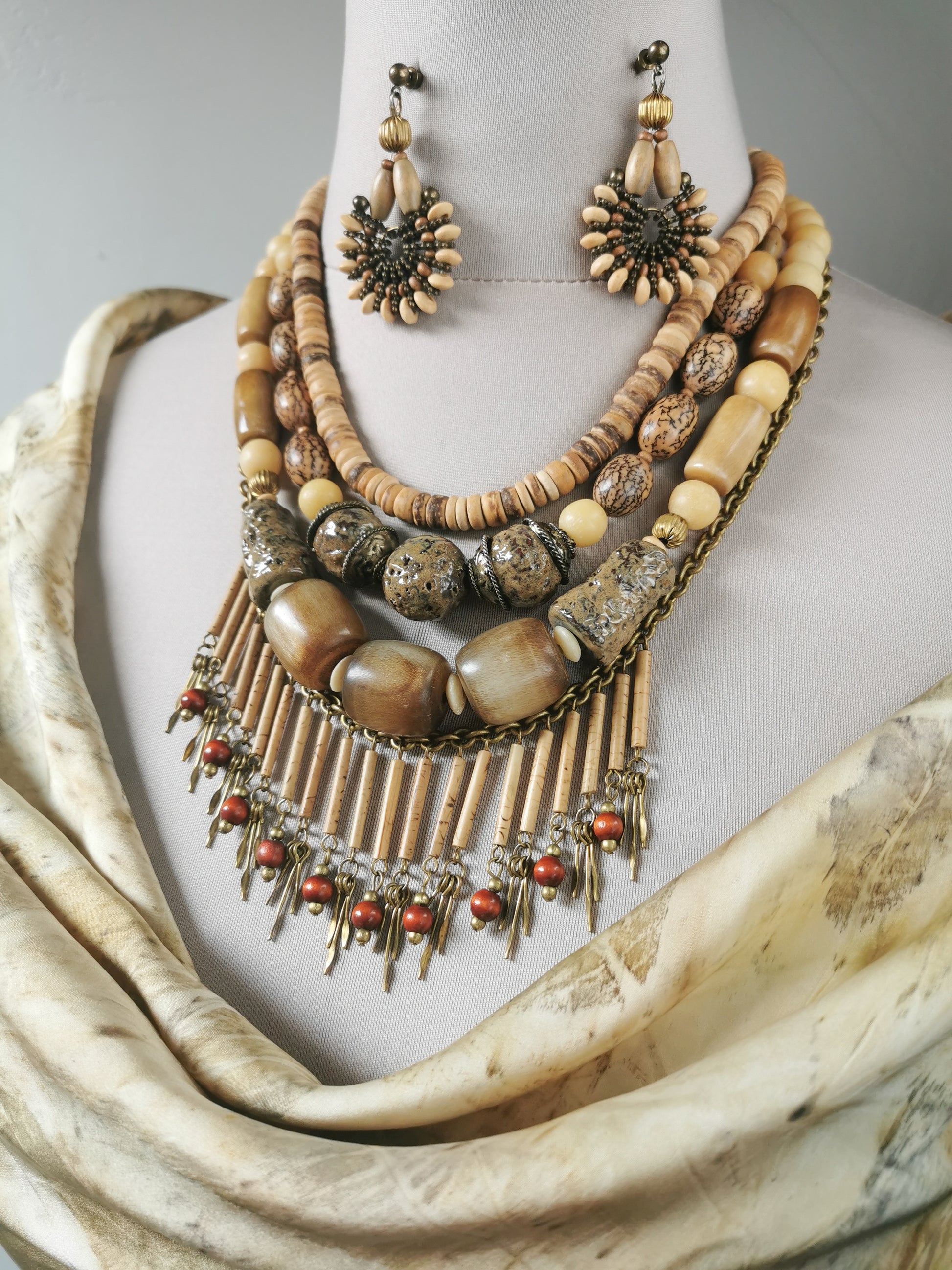 Necklace and earrings set on a mannequin with a neutral background
