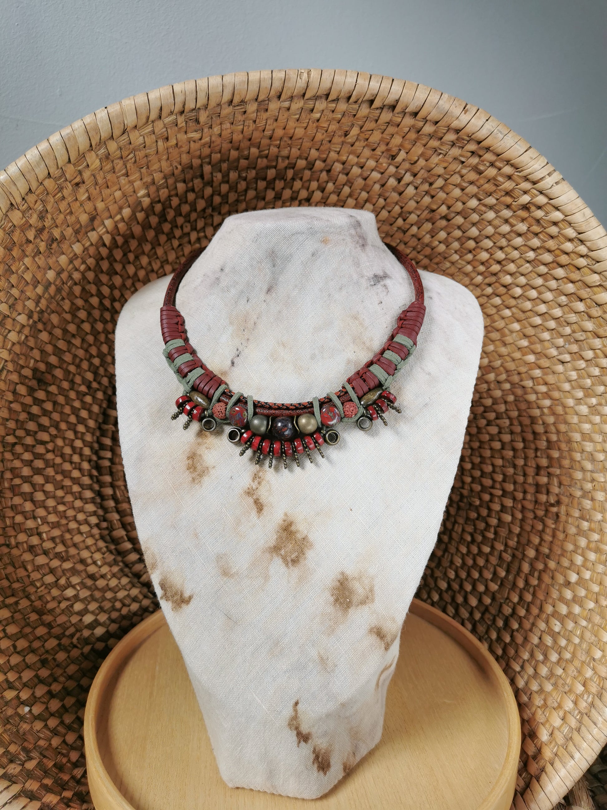 Necklace on a white stone bust with a woven basket background