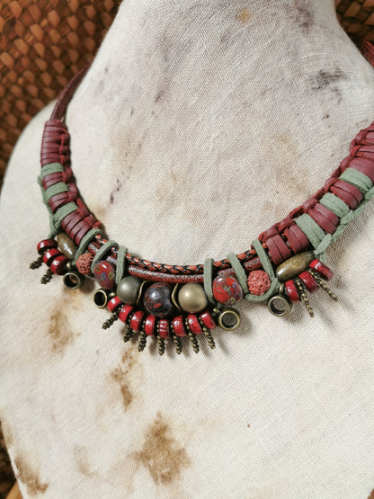 Necklace with red and green beads on a textured surface