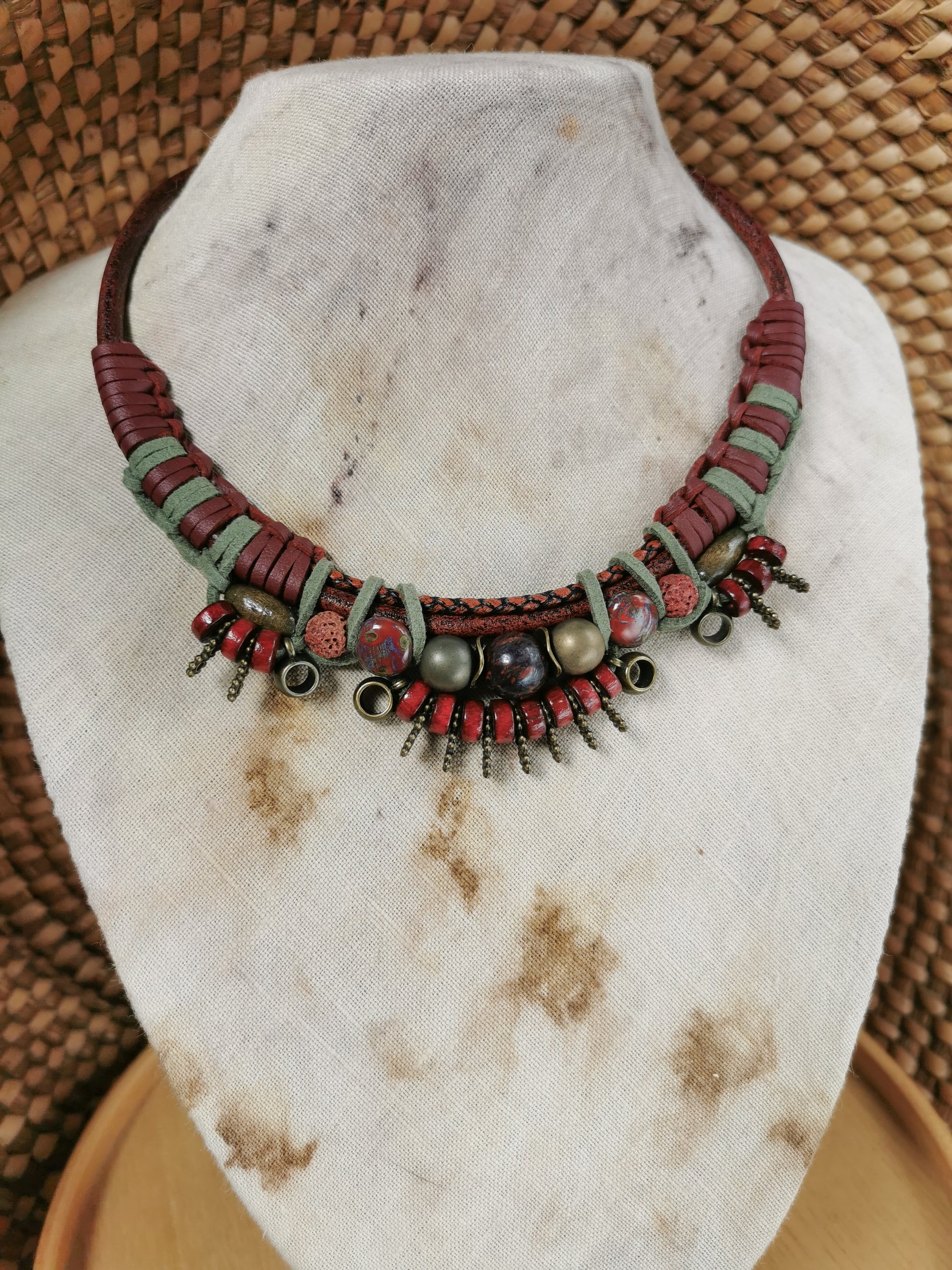 Necklace with red and green beads on a stone surface