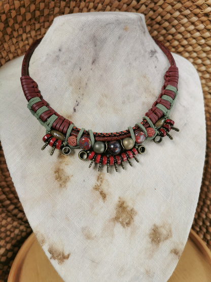 Necklace with red and green beads on a stone surface
