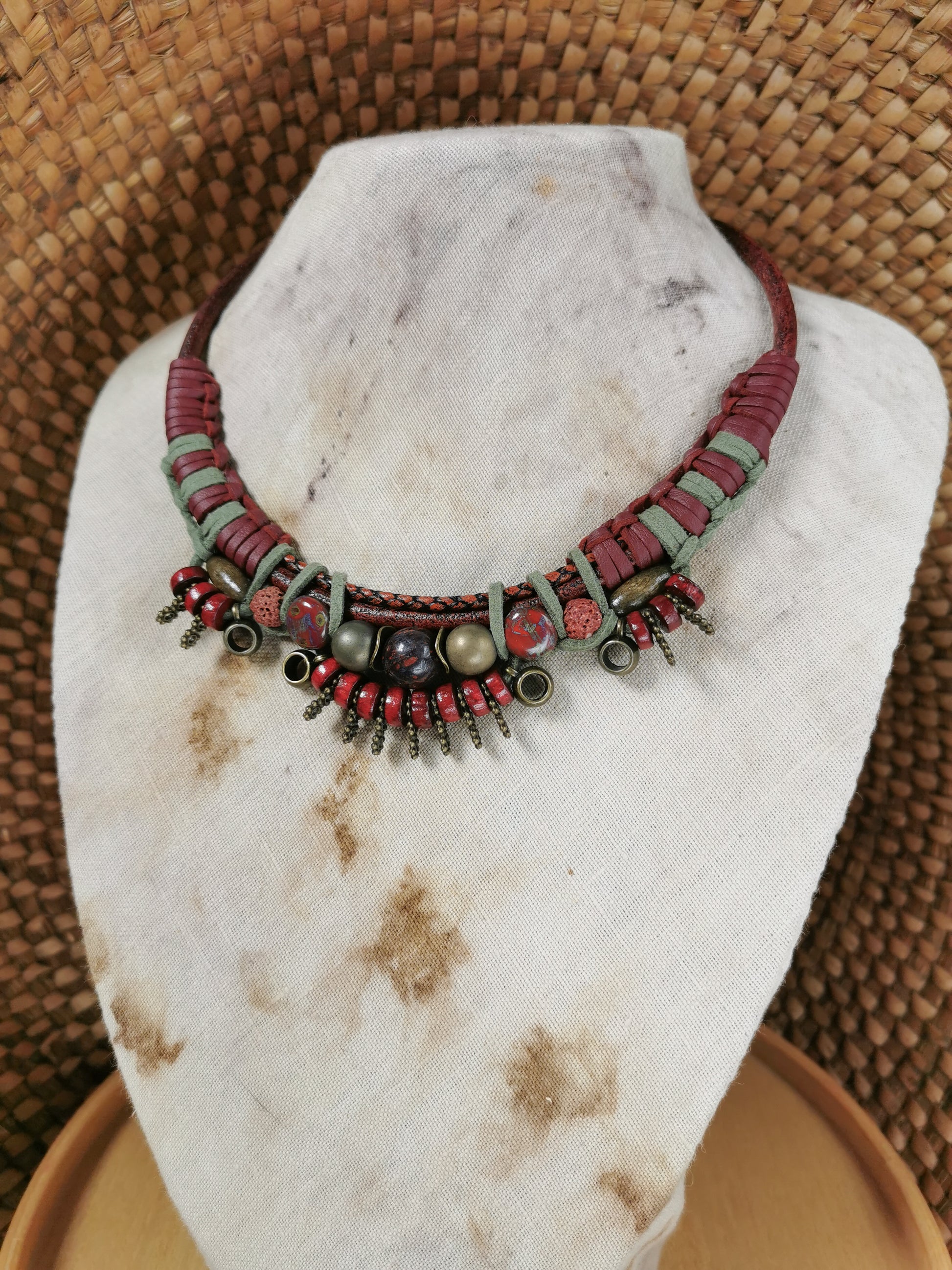 Necklace with red and green beads on a marble stand