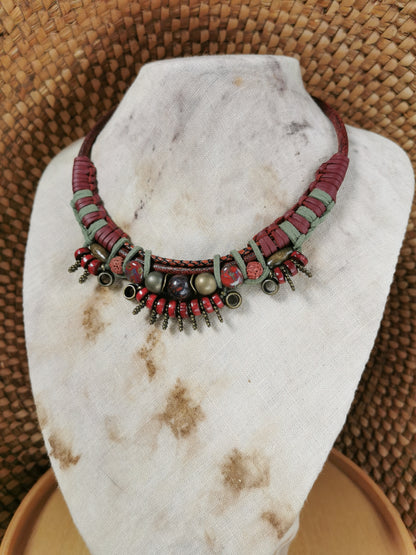 Necklace with red and green beads on a marble stand
