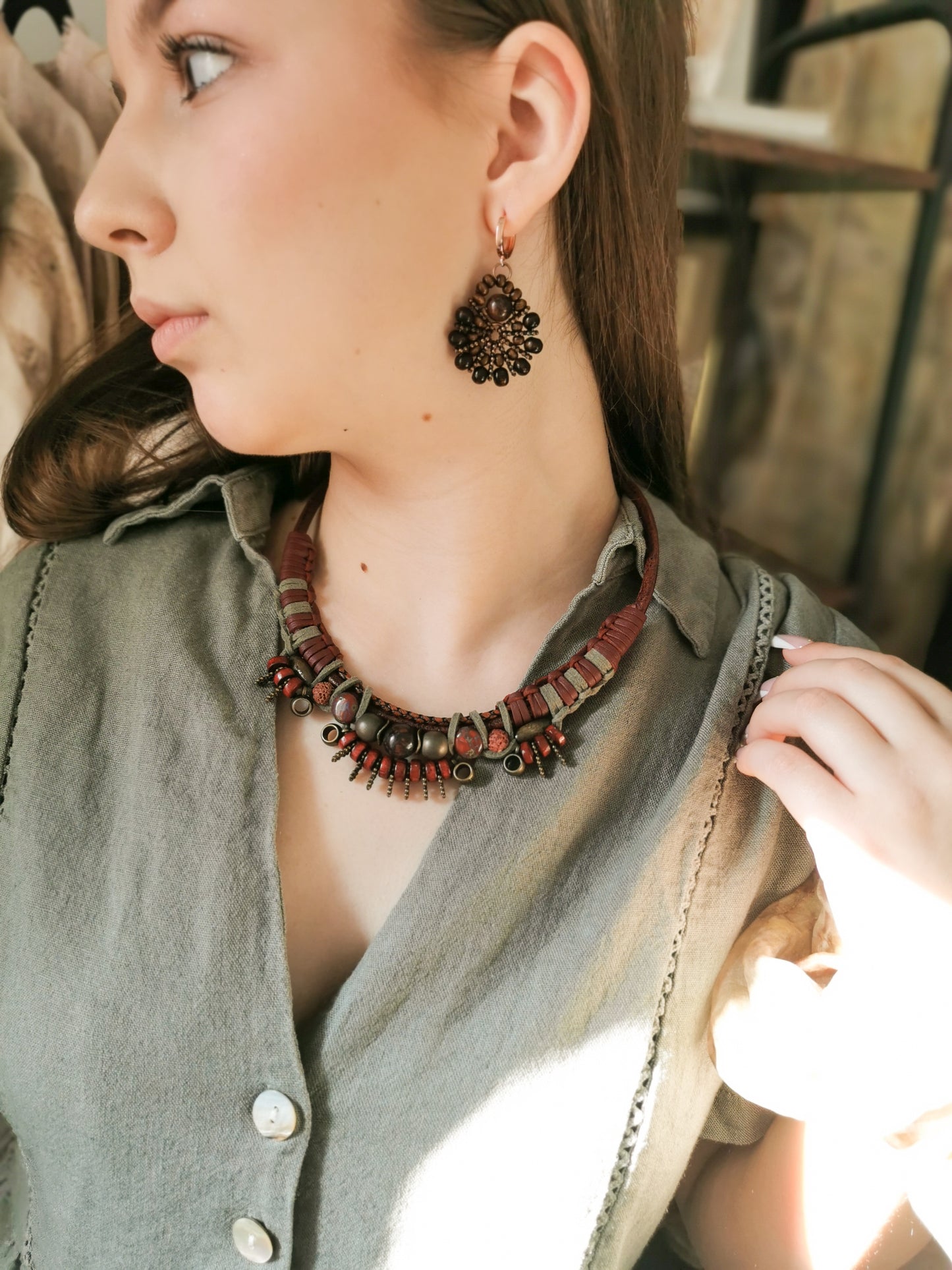 Woman wearing a necklace and earrings with a blurred background