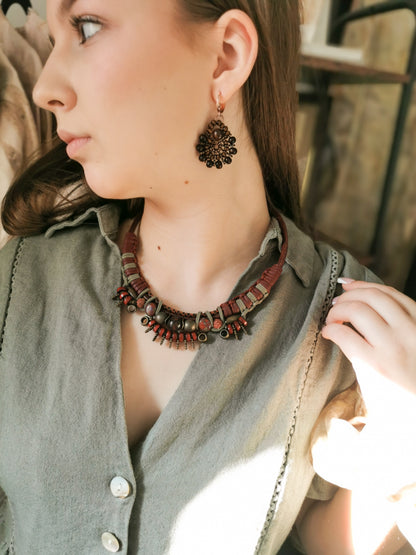 Woman wearing a necklace and earrings with a blurred background