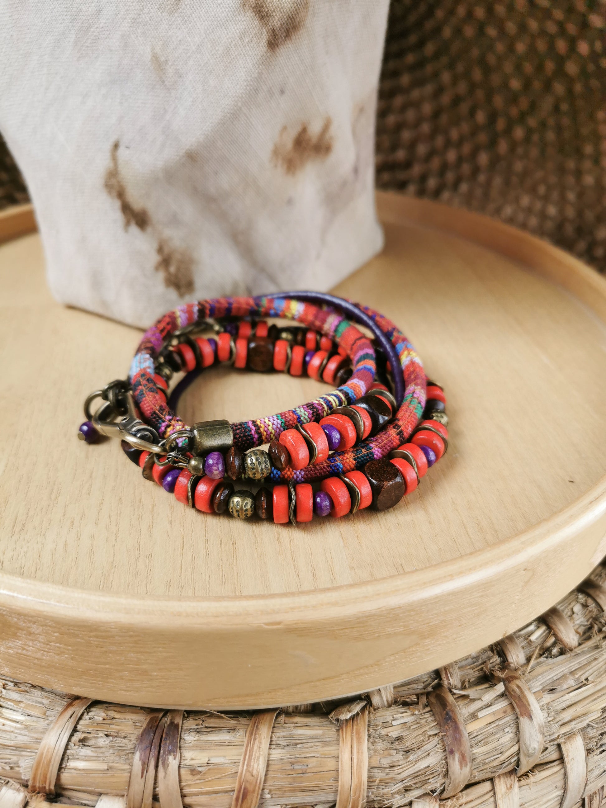 Multicolored beaded bracelet on a wooden surface with a woven mat background