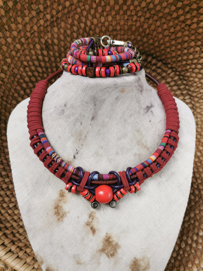 Colorful beaded necklace and bracelet set on a white marble stand with a textured brown background