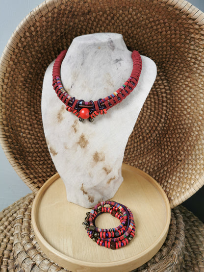 Red and black beaded necklace on a marble stand with a woven basket background