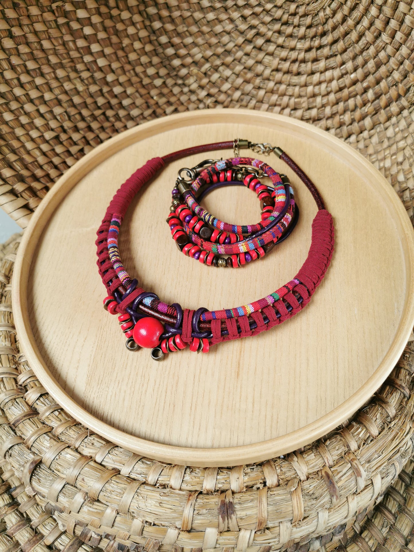 Colorful beaded necklace and bracelet set on a woven surface